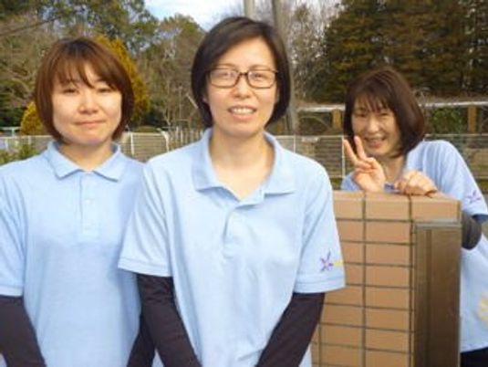 笑顔のスタッフが並ぶ外観前  