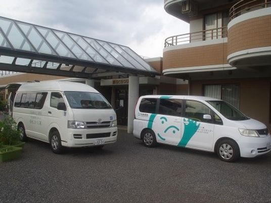 施設の外観前の車両  