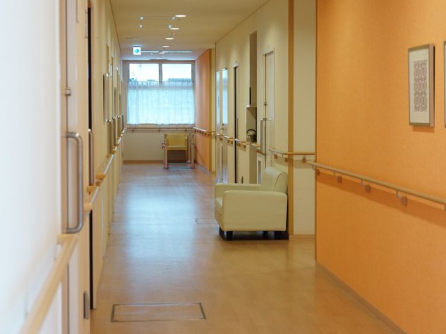 明るい廊下 明るくぬくもり感のある通路 床には滑りにくい素材が使用され、壁には手すりが設けられており、歩行が不安な方も安心してご利用いただける廊下です。