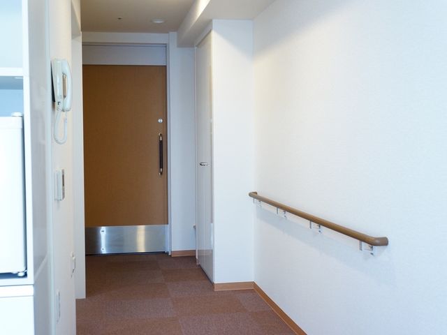 清潔な廊下の一角 居室 手すりが設置された明るい廊下です。安全に移動ができるように配慮された設計となっています。