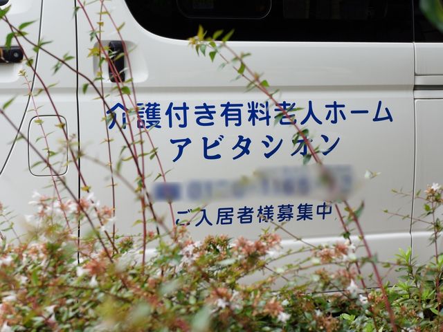 和やかな花の前の車両 専用車 清潔感のある車両が見え、移動の際の快適さを示唆しています。外出支援の一環として、利用者様の安全運転が期待できます。
