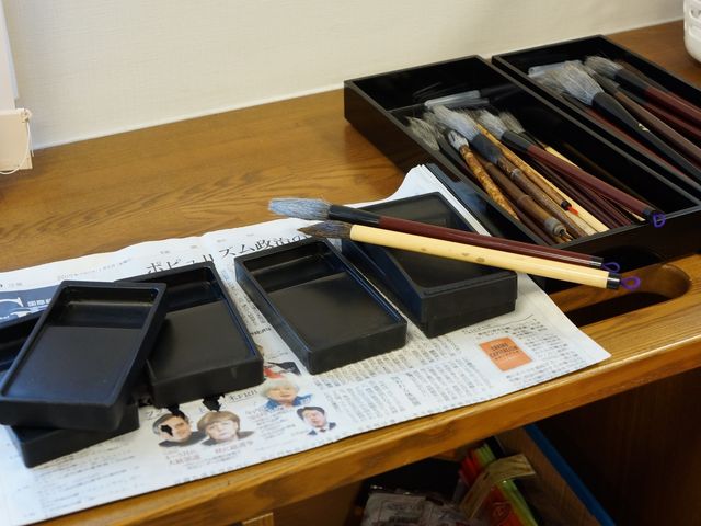 書道用具のテーブル 習字 手入れが行き届いた書道用具が整然と並べられ、創造的活動を楽しむための環境が整っています。趣味や特技を大切にしたい方に適した施設です。