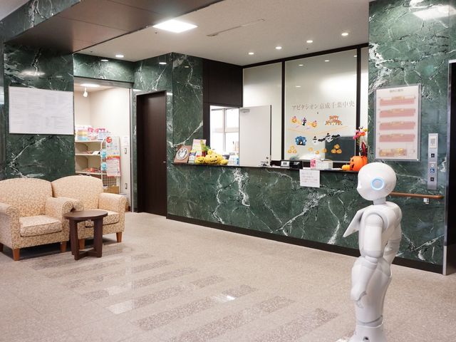 応接スペースとロボット 受付 応接用のソファが備えられた受付エリアです。最新技術のロボットが訪れる方を温かく迎えます。