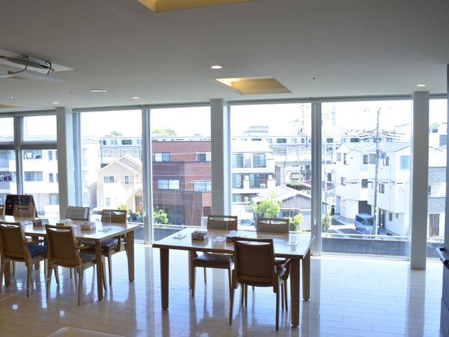 窓際に並ぶ広いテーブル ダイニングルーム 明るい光が差し込む広々とした食事スペースです。大きな窓が特徴で、開放感があります。