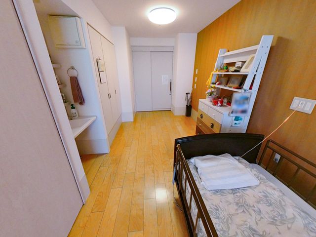 明るい居室 居室 ベッドサイドに収納が充実した居室です。木目調の床が温かみを感じさせます。