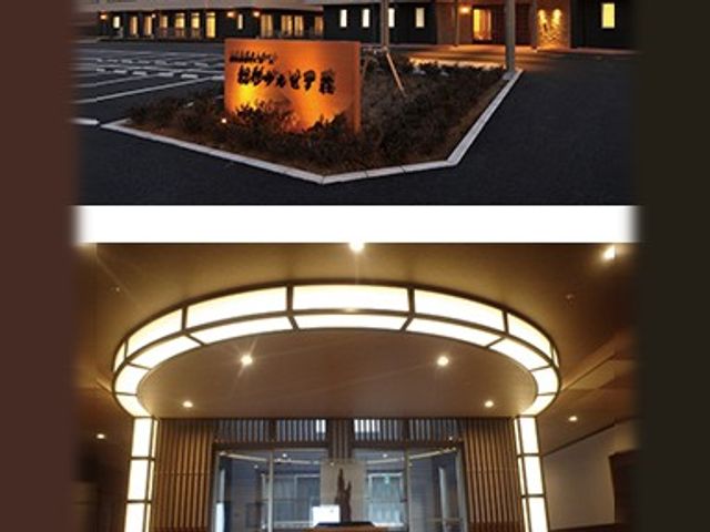 看板とロビー入口 外観   夜間に灯る看板が目を引く、落ち着いた雰囲気の出入口です。上階へ続く明るいロビーも見えて、働く場の印象をつかみやすいです。