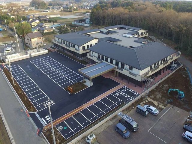 静かな外観の建物 外観 広々とした駐車場があり、車でのアクセスも便利です。周囲には自然が広がっています。