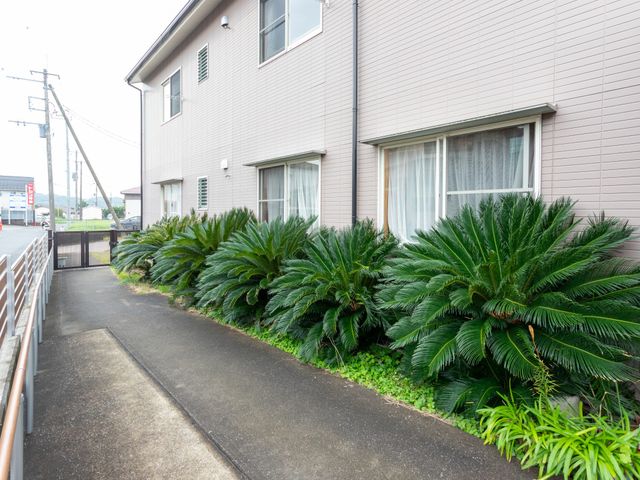 手入れされた植栽の庭 庭 建物の外には手入れが行き届いた緑豊かなスペースがあります。散歩や休息に最適な環境です。