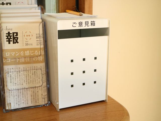 受付案内と雑誌スタンド ご意見箱 清潔感のある受付周辺です。情報提供や雑誌の整理も行き届いており、待ち時間も快適に過ごせます。