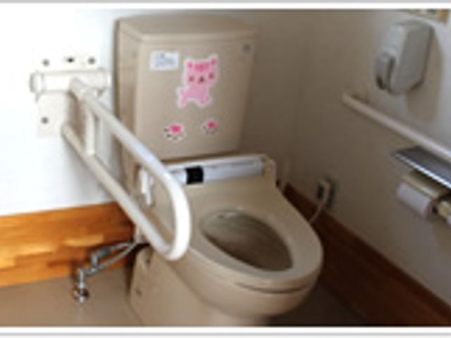 清潔な設備のトイレ トイレ 安全に配慮した手すり付きのトイレです。可愛らしい装飾が施されており、安心して利用できます。