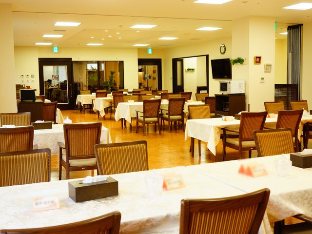 広々とした明るい食堂 食堂 清潔感のあふれる広い食堂は、居心地の良い時間を過ごせる空間です。木目調の家具が温かみを与え、憩いの場を提供しています。