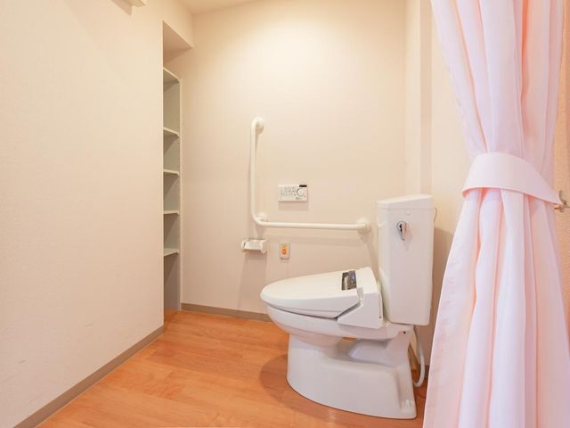 居室トイレ お部屋には、歩行器や車いすでも入れる広さの温水洗浄機能付トイレを完備。手すりやケアコール付きで、介護スタッフも呼べるから安心してご利用いただけます。