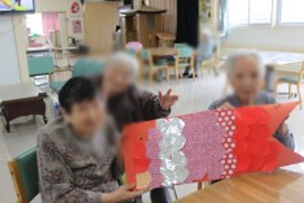作品を見せる様子の女性たち