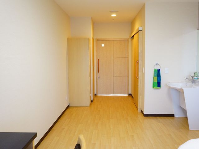 居心地の良い居室風景 施設内の個室 ゆったりとした間取りの居室です。温かみのあるカラートーンと木目調の家具が穏やかな雰囲気を醸し出しています。