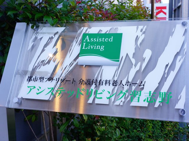 明るい看板のクローズアップ 施設名看板 迎える門に掲げられた看板が目印です。清潔感漂うデザインは訪れる人に安心感を与えます。