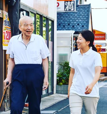 散歩する高齢者とスタッフ