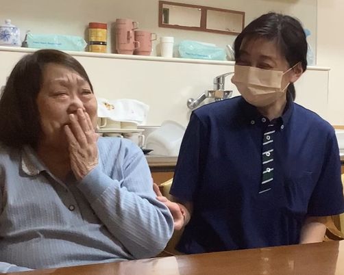笑顔交わすスタッフと入居者