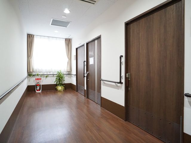 明るい清潔な廊下 廊下 床には滑りにくい素材が使われ、手すりも設置されており、安全に気遣った設計になっています。窓からは自然光が差し込み、開放的な雰囲気を感じることができます。
