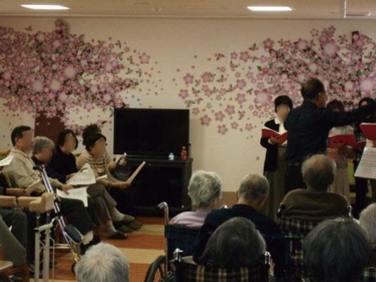 桜の花のデコレーションがされた共通スペースで、コンサートを楽しむ様子。地域交流や音楽の催物などを多く行っている。