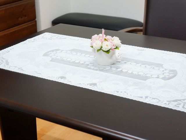 テーブル上の花とレースクロス 居室 上品なレースのクロスが敷かれたダイニングテーブルです。清潔感のある食空間での食事が楽しめそうです。