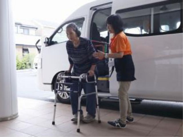 スタッフ介助の入口シーン 通院介助 丁寧な介助を受けながら、お一人お一人が安心して移動できるエントランスです。