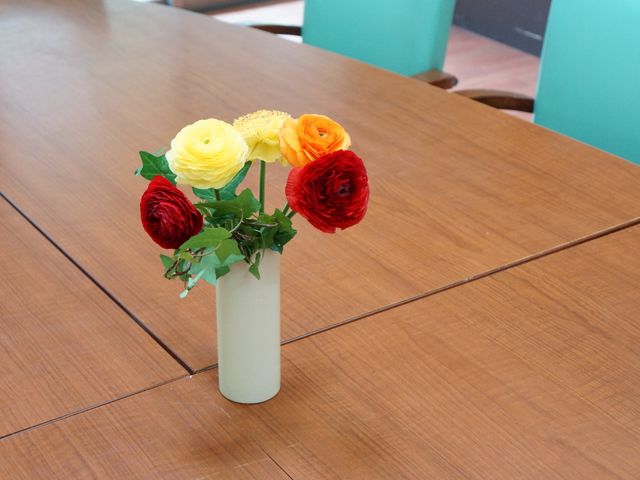 色鮮やかな花とテーブル インテリア テーブルに彩られた生花が、明るい食堂の雰囲気を和ませています。毎日の生活に潤いを提供してくれる空間です。