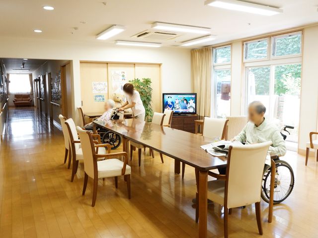 明るいダイニング風景 リビングダイニング ゆとりある空間で食事が楽しめるダイニングです。明るい窓辺でスタッフがお世話をしています。