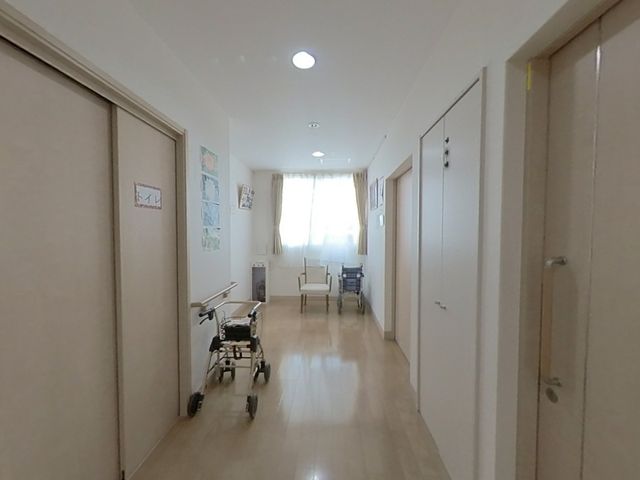 明るい廊下 廊下 自然光が差し込む廊下は、歩行訓練用の手すりが備え付けられ、安全に配慮されています。