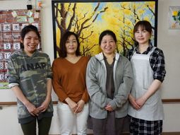 笑顔のスタッフ四名立ち姿