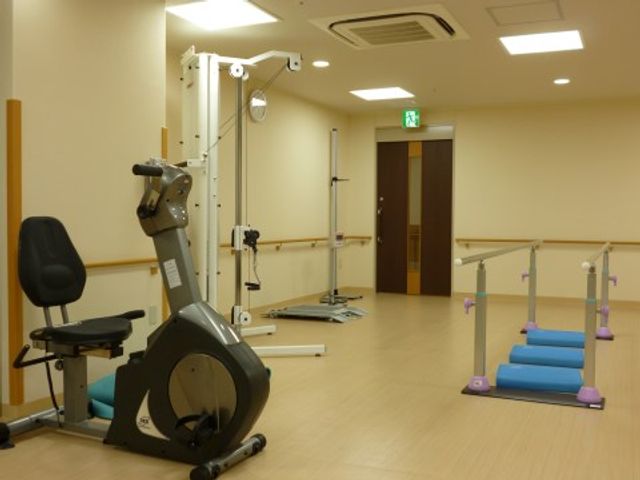 機能訓練用具が整う部屋 リハビリ室 明るい照明の下、適切な機能訓練器具が配置された部屋です。日々のリハビリに利用でき、施設利用者の健康維持のお手伝いをします。