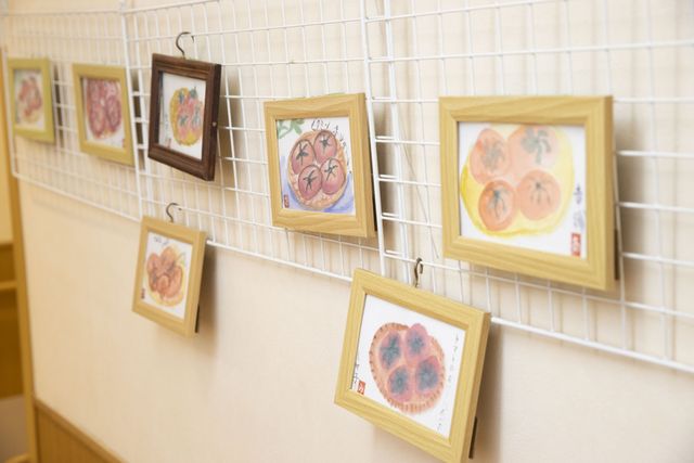 廊下の壁に飾り額 廊下   明るい廊下の壁に、利用者の作品と思われる額が並んでいます。歩きながら作品を楽しめる、温かい雰囲気の通路です。