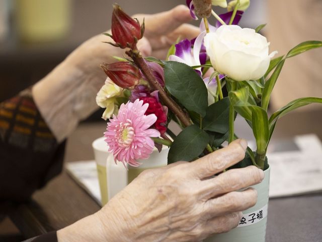 花を活ける手元 多目的室   手元で花を整える様子が見え、落ち着いた雰囲気の中で行う活動の場です。利用者の方の参加を支えやすい空間です。