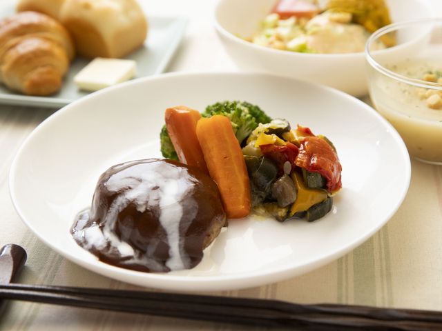彩り豊かな食事 食堂   彩りのよい食事が並び、パンや温かい料理も見えます。食事の時間が楽しみになる、やさしい雰囲気です。