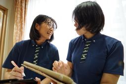 笑顔のスタッフがタブレットを見る