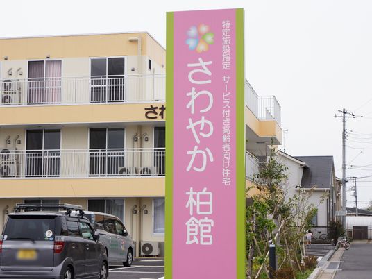 黄色い外壁の建物と看板