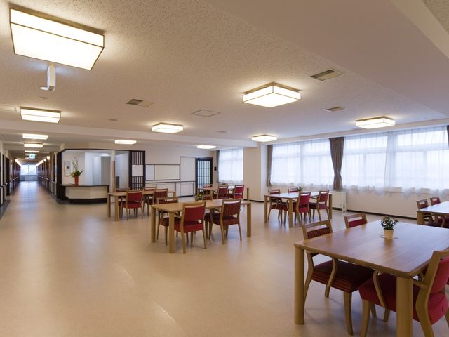 広々ダイニングスペース カウンター 明るく清潔な食事スペースが広がり、快適な就業環境が整っています。フローリングの床が印象的です。