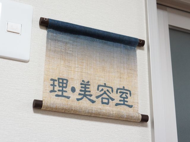 壁掛け和風の掲示物 理美容室 温もり感じる和風デザインの掲示物が、心地よい空間を演出しています。