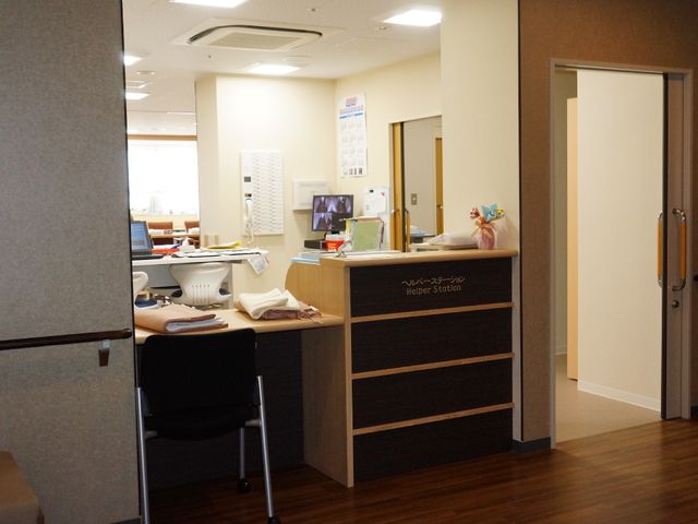 明るいスタッフの受付 ヘルパーステーション 清潔感のある受付スペースでは、作業に集中するスタッフの姿が見受けられます。