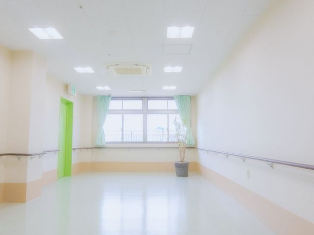 広い廊下 廊下 手すりのある安全な通路は、自然光が優しく差し込む明るい空間です。