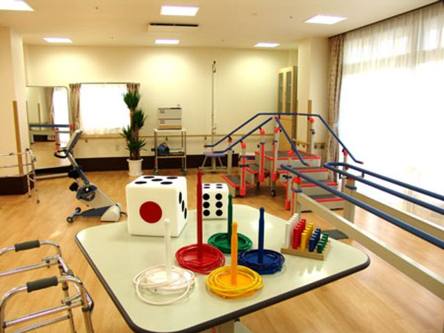 運動器具が並ぶ部屋 機能訓練室 広い空間に設置されたさまざまな運動器具で、安心してリハビリ活動を行えます。自然光が心地よい場所です。