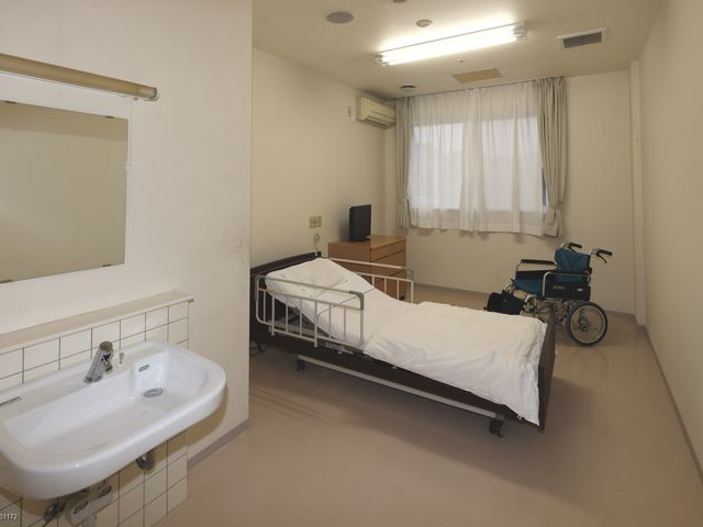 清潔感のある居室 居室 明るい自然光が差し込む部屋です。介護ベッドや車椅子も設置されており、快適に過ごせます。