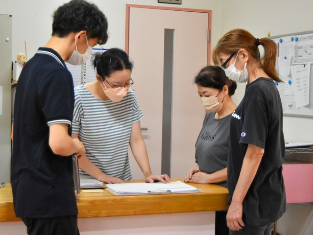 スタッフイメージ スタッフイメージ スタッフが協力し合い、入居者様のケア計画を確認しています。和やかな雰囲気の中で働けます。