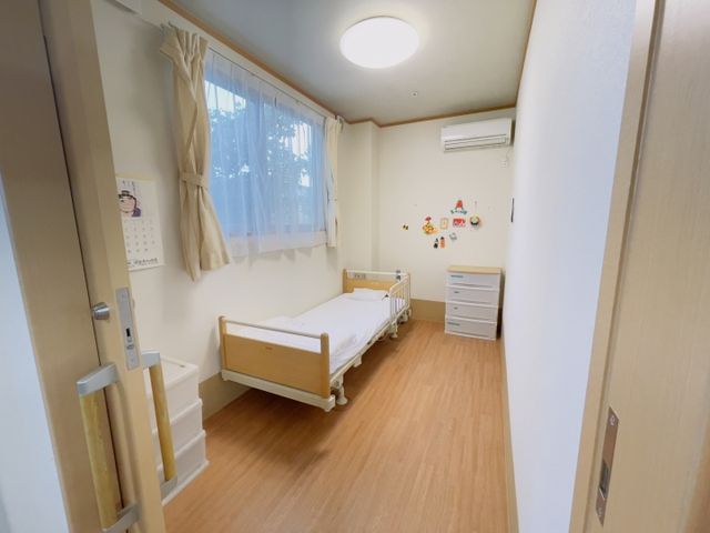 シンプルな居室 居室 シンプルな内装で、落ち着いた雰囲気の居室です。木製のベッドと明るいフローリングが特徴です。