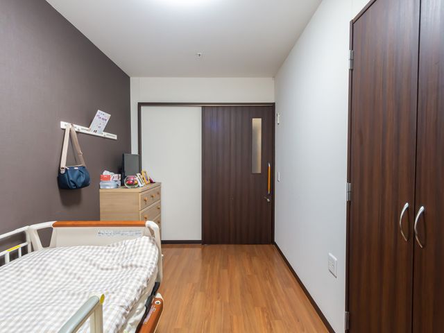居室の端正な印象 居室 ゆったりとしたベッドと整理された収納がある部屋です。充分なプライバシーと快適さを備えた空間です。