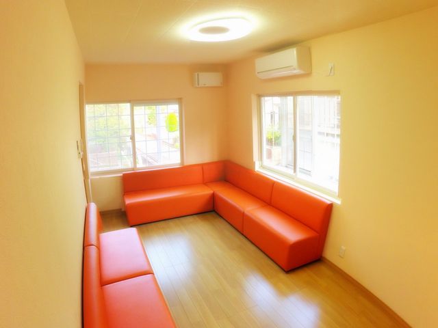 明るいオレンジのラウンジ ラウンジ 自然光が差し込む明るいラウンジです。ゆったりとしたソファでくつろぎながら休息できます。