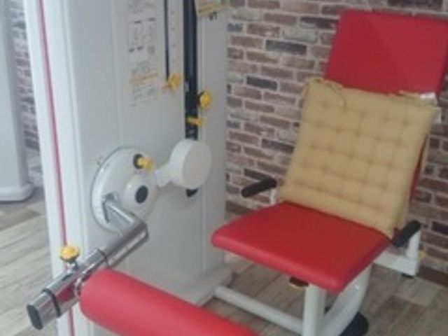 運動機器がある部屋 機能訓練室 木目調の床と赤色の運動機器がある機能訓練室です。快適なリハビリをサポートします。