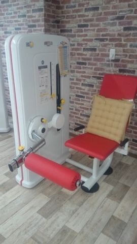 運動機器がある部屋 機能訓練室 木目調の床と赤色の運動機器がある機能訓練室です。快適なリハビリをサポートします。