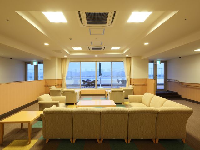 明るい共有ラウンジ ４階談話室 開放的なラウンジでは、ゆったりしたソファでくつろぎながら窓外の景色を眺めることができます。こちらでのひとときを仕事の一環としてサポートしていただける方を募集しております。