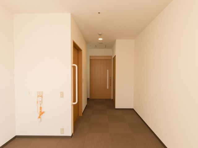 廊下の清潔な空間 居室 明るく清潔感のある廊下は、ゆとりのある空間で移動がしやすく配慮されています。静かで落ち着いた雰囲気が、快適な勤務環境を予感させます。