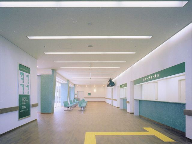清潔感ある明るい廊下 誠佑記念病院（併設）窓口 広々とした廊下はバリアフリー設計で、壁には情報掲示板が備えられ、待合いスペースも用意されています。